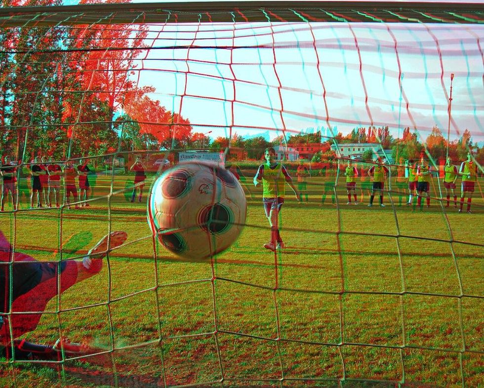 A photo of a football going in a net