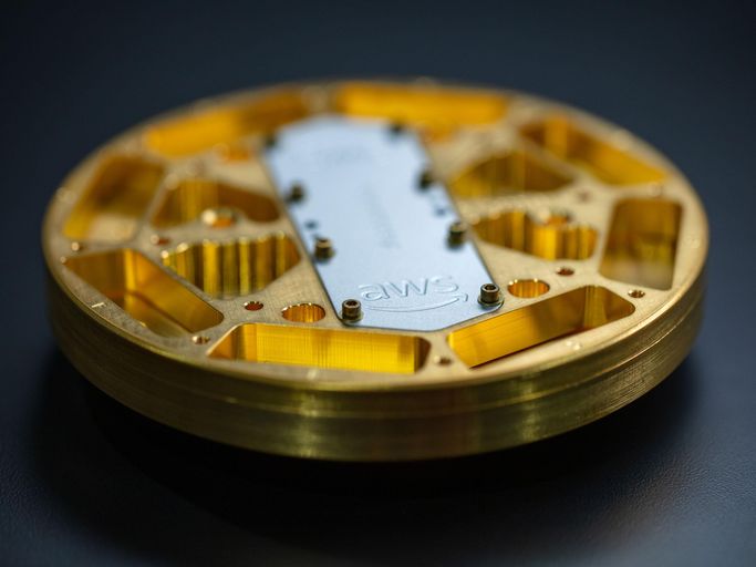 A photo of a golden disc with a silver plate labeled "AWS" bolted on top.