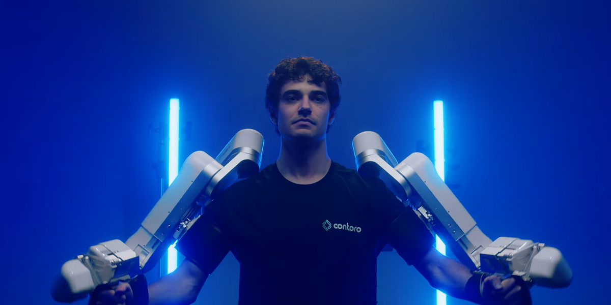 a photo of a human with two white robotic arms strapped to their arms