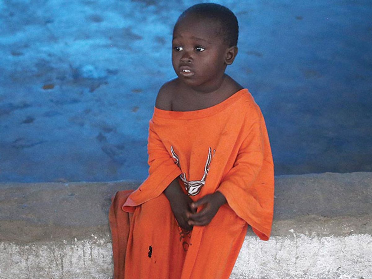 A photo of a Liberian child sitting in an Ebola isolation ward