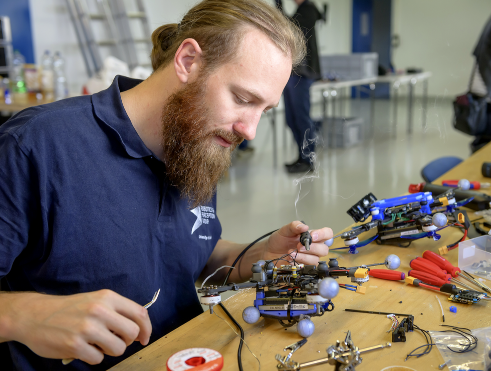 A photo of a man repairing a drone.  