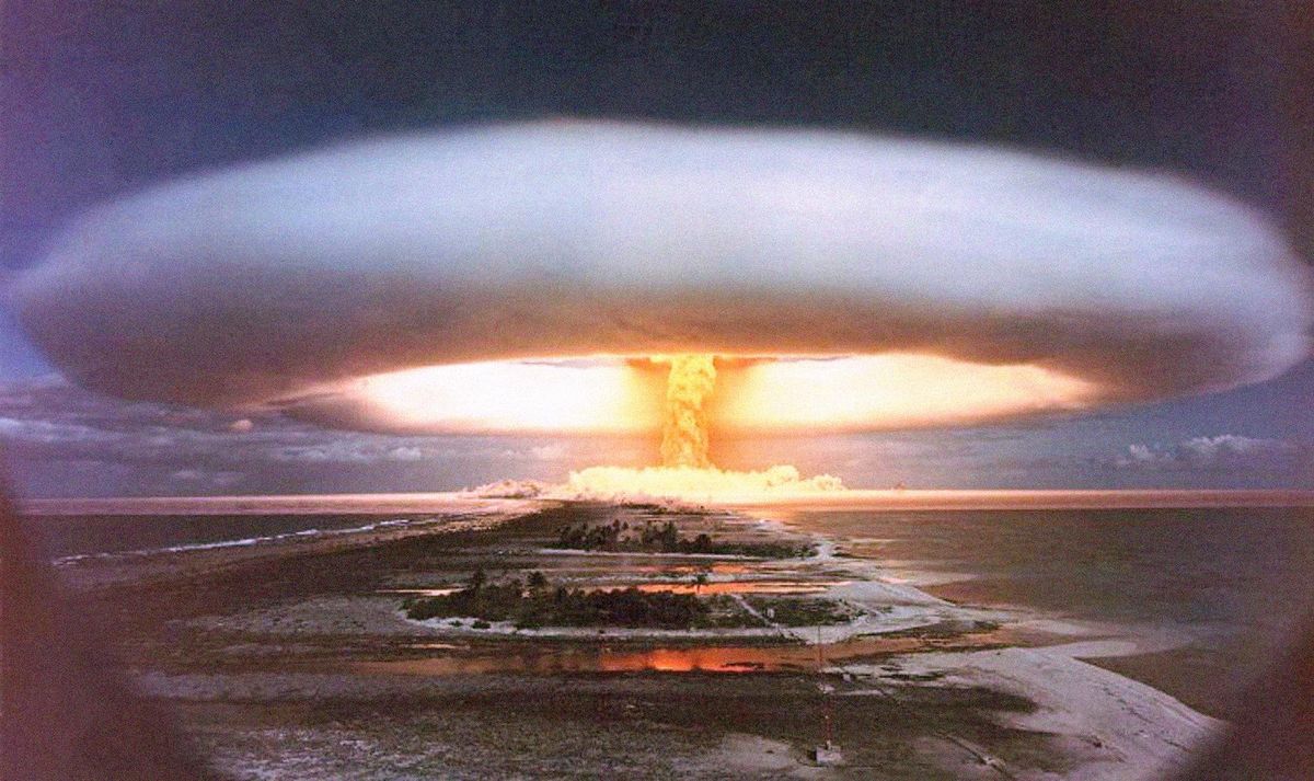 A photo of a nuclear explosion with islands in the foreground.