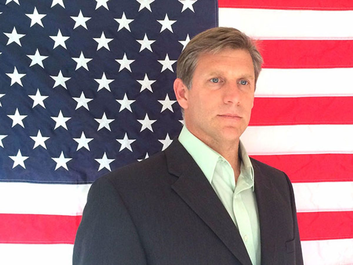 A photo of Transhumanist Party presidential candidate Zoltan Istvan standing in front of an American flag.