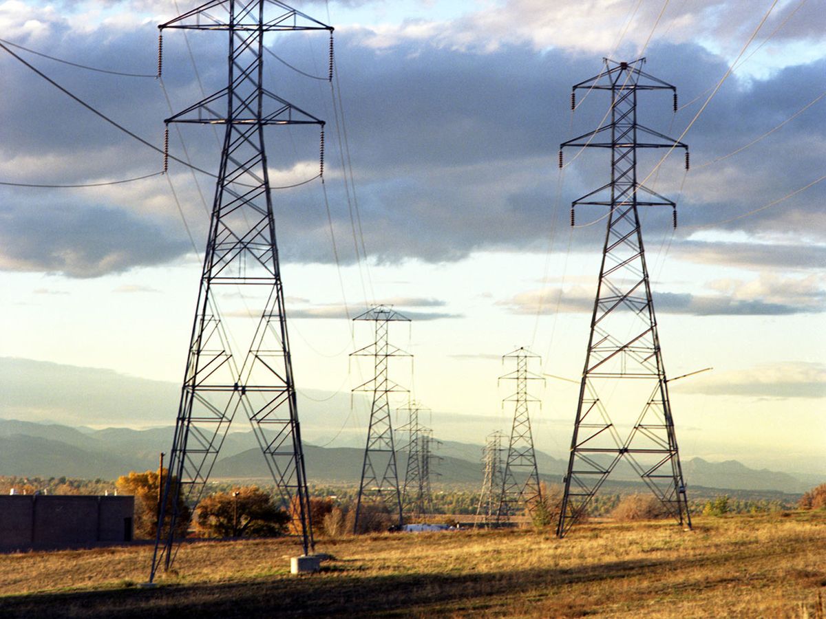 A photo shows high-voltage transmission lines crossing an open field.