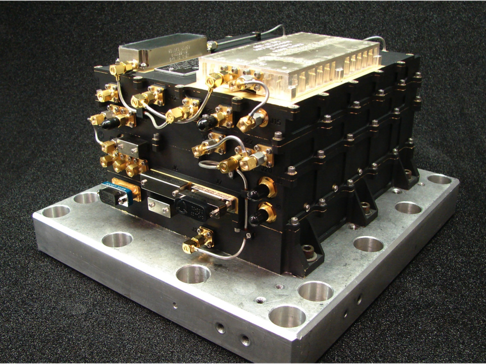 A photograph of a black radio unit sitting on a metallic block.