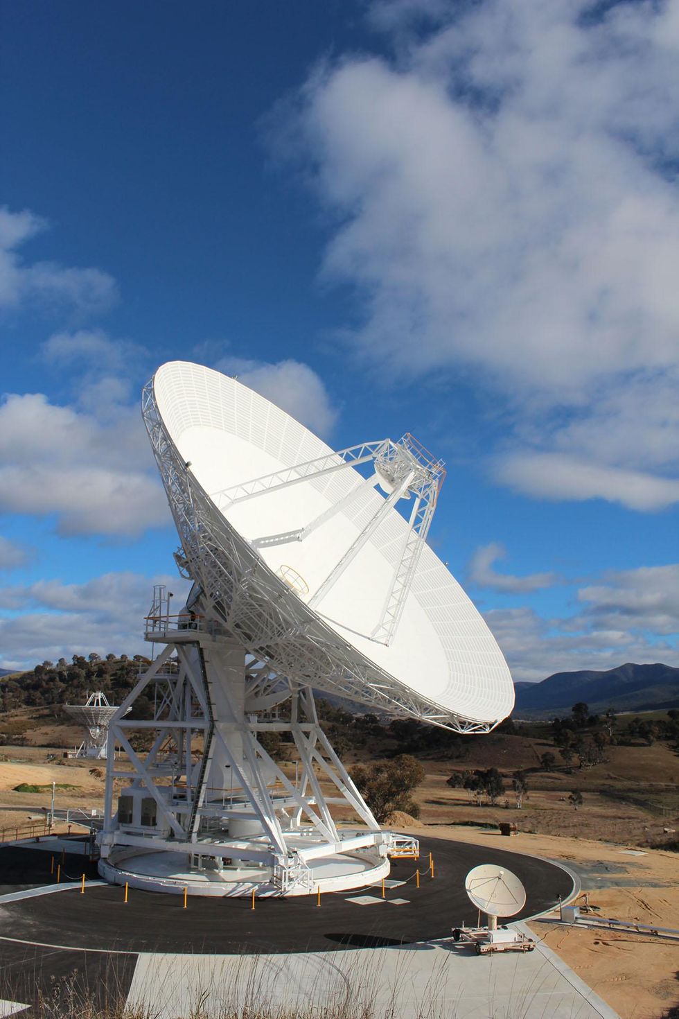 A photograph of a large radio antenna dish in front of a blue sky.