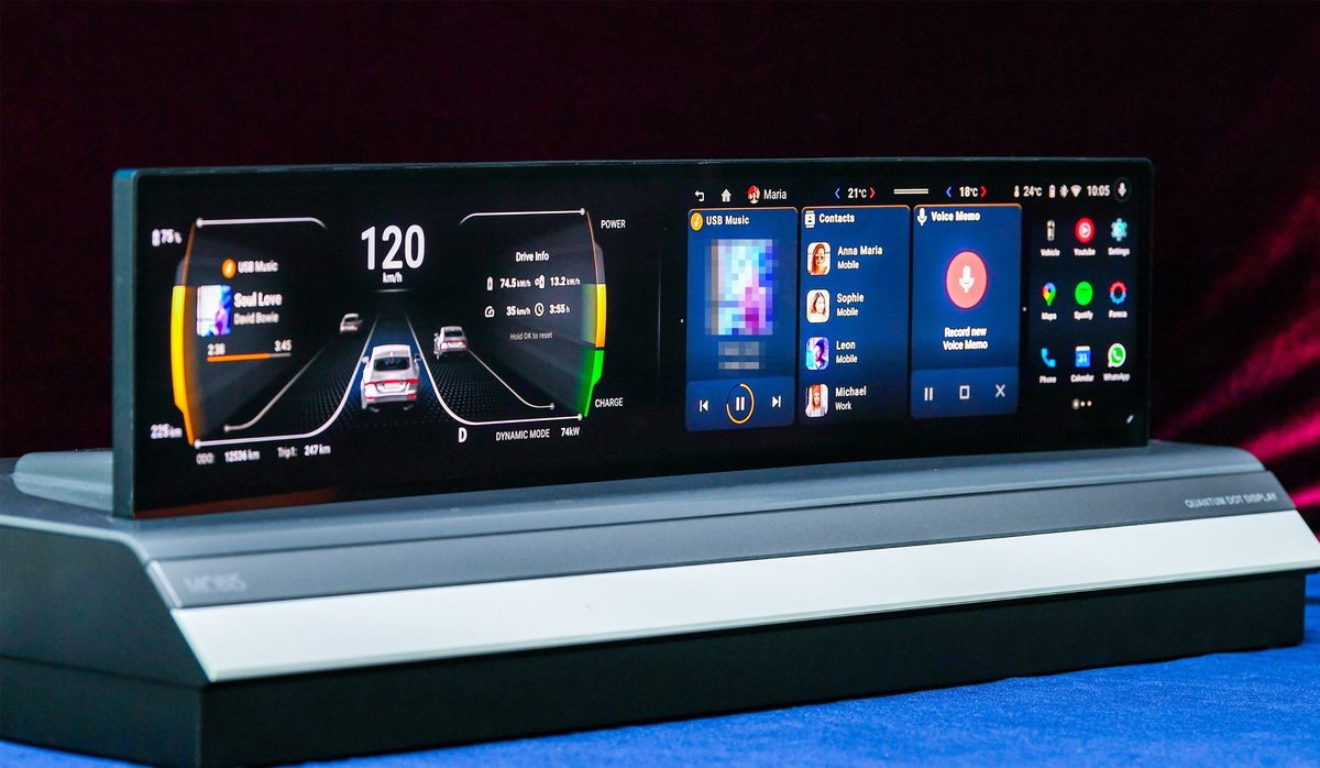 A platform with an automotive display. The shape is mostly horizontal, and has multiple screens, including one showing car speed and road placement, music, contacts, and apps.