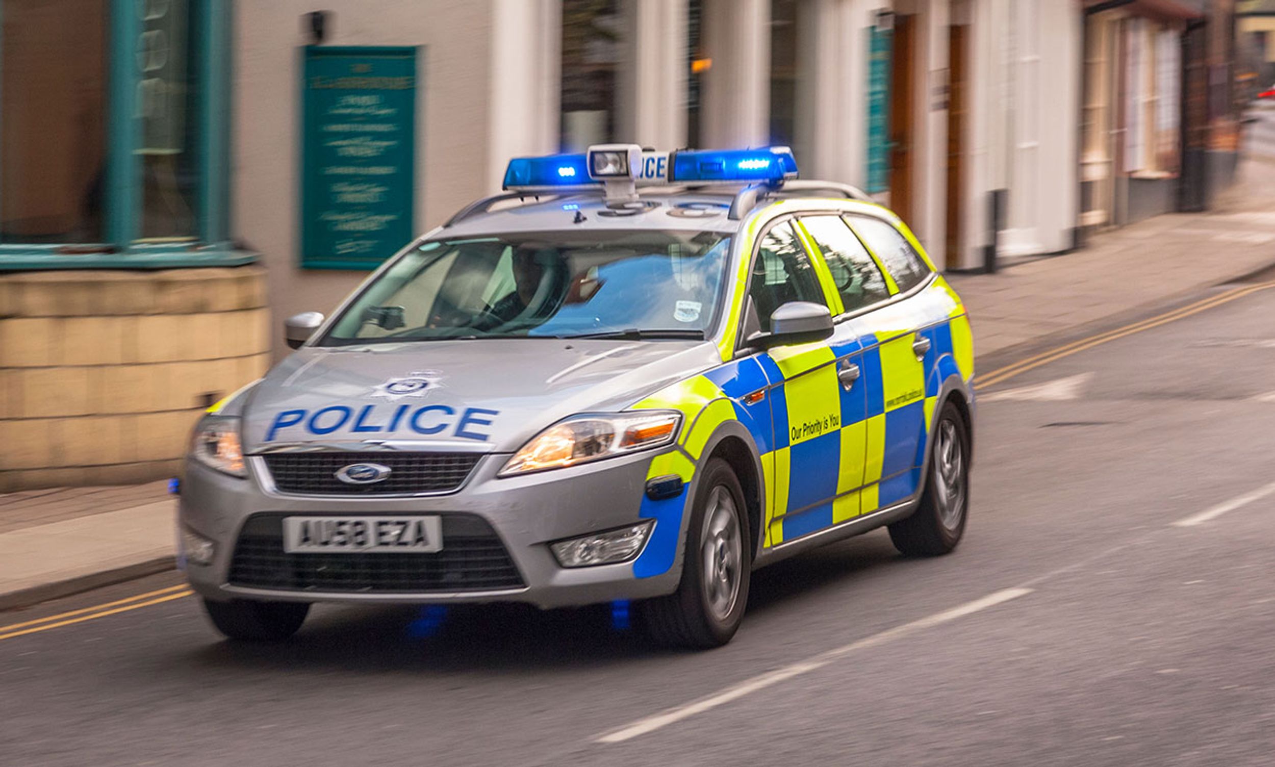 A Police car with blue lights flashing in Norwich, Norfolk, England, Britain, UK