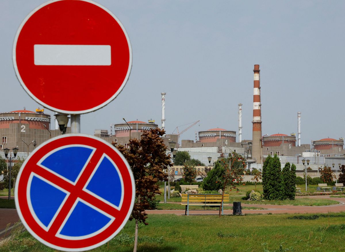 A power plant seen in the distance, with road signs in the foreground