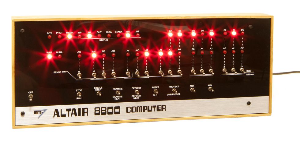 A rectangular box with bright red lights and switches. The bottom metallic section says Altair 8800 Computer.