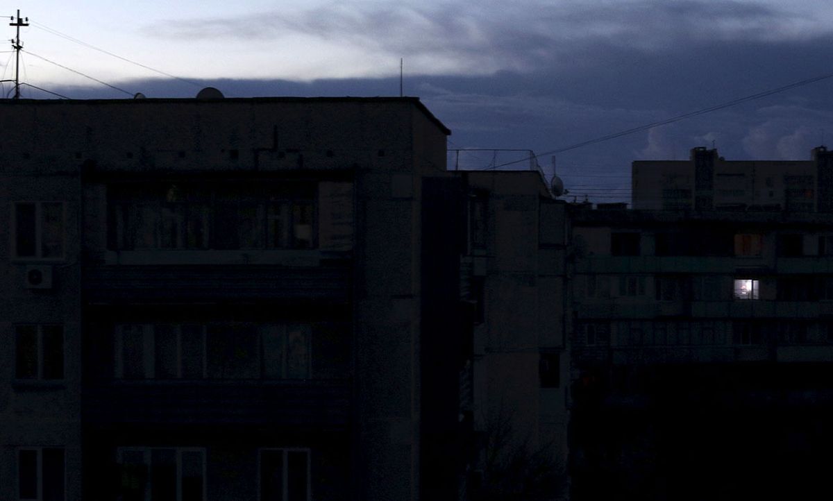 A single light illuminates a room during a blackout in Ukraine, 2015.
