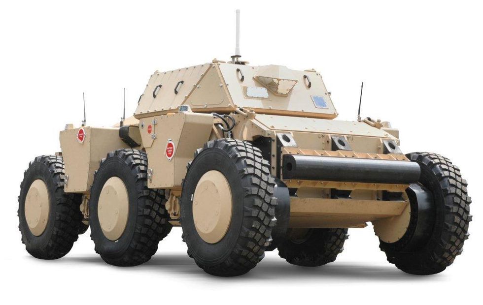 A six wheeled beige vehicle that looks like a tank without a gun in the turret