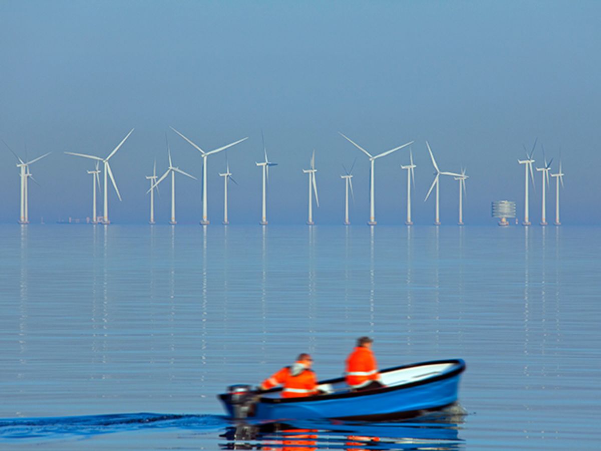 A small boat goes past the Lillgrund offshore wind farm