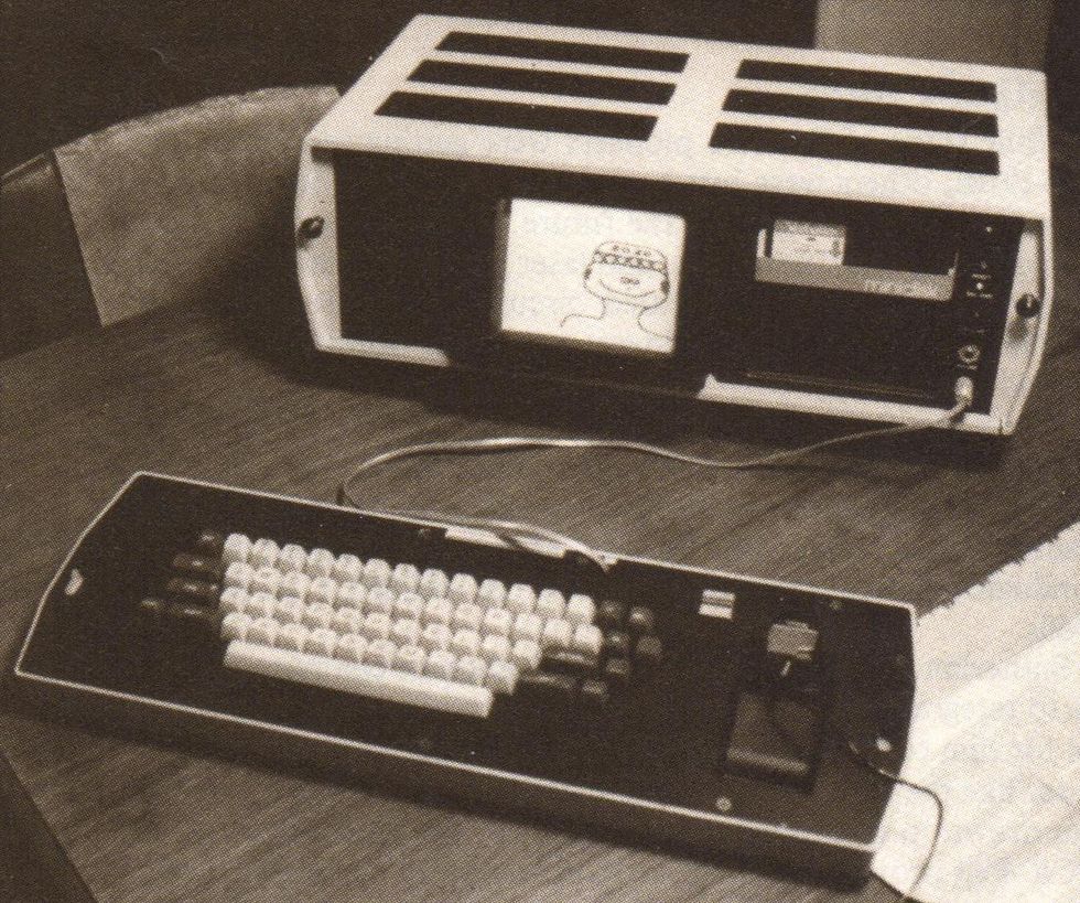 A small computer with floppy disk slots and a built in screen with a detached keyboard