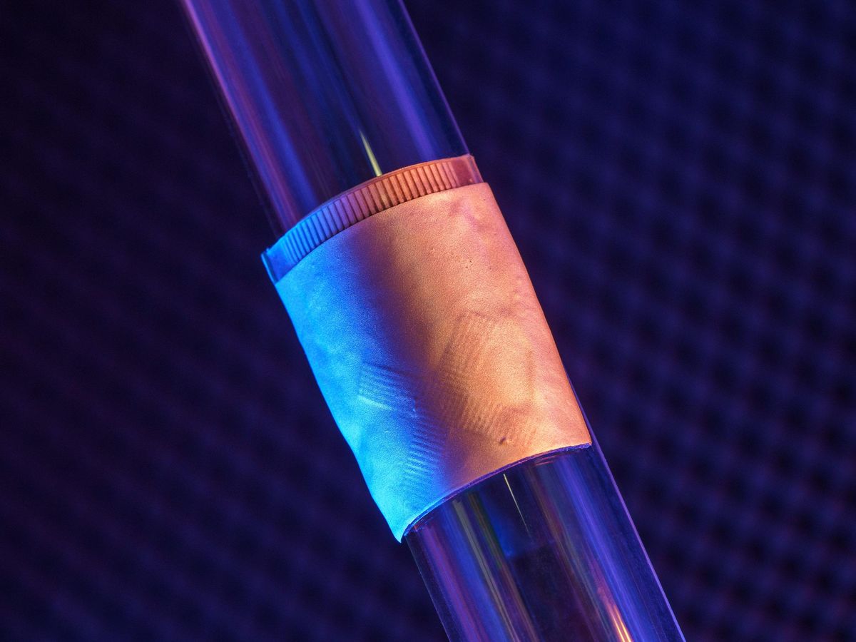 a small patch is wrapped around a cylinder in front of a dark background