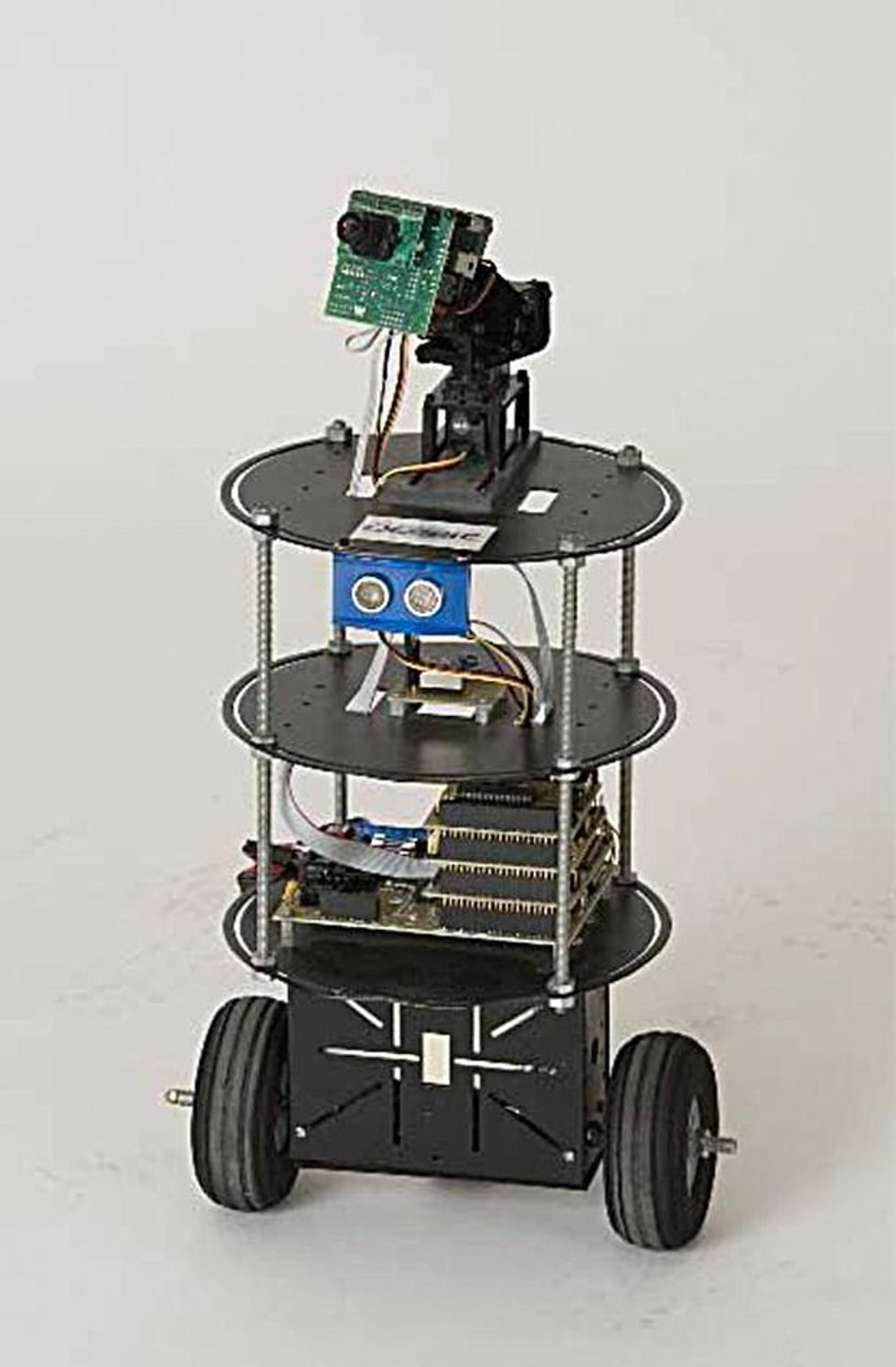 A small two wheeled robot with exposed electronics, camera, and sonar sensor