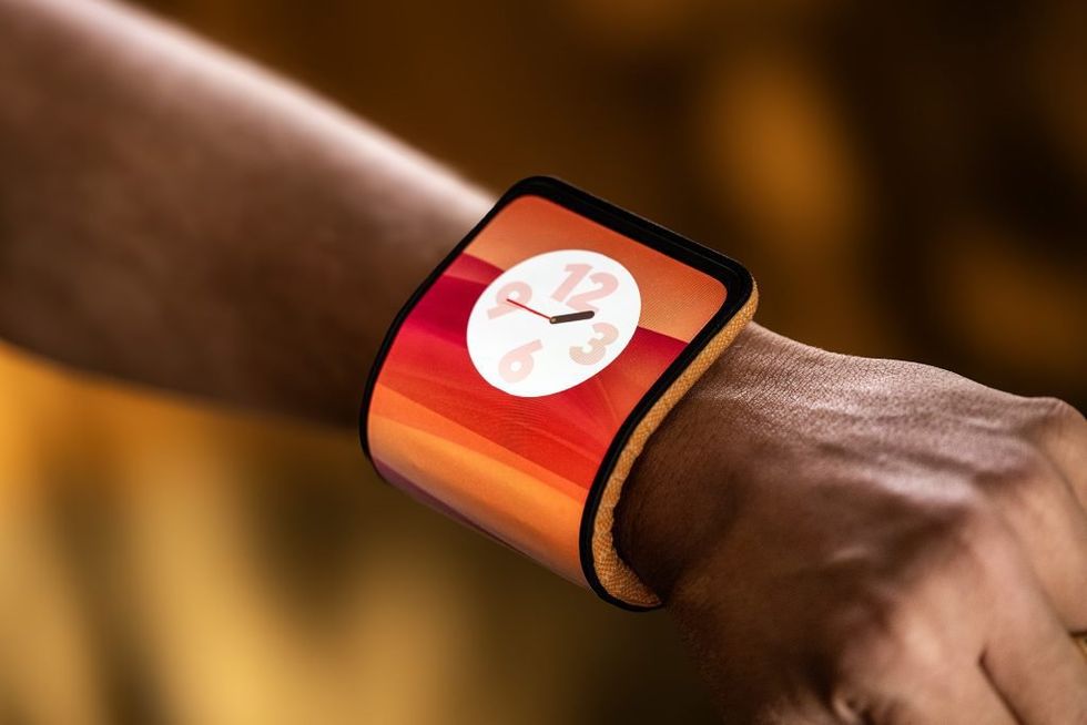 A smartphone with a flexible display wraps around the wrist of a person to look like a wide watch.
