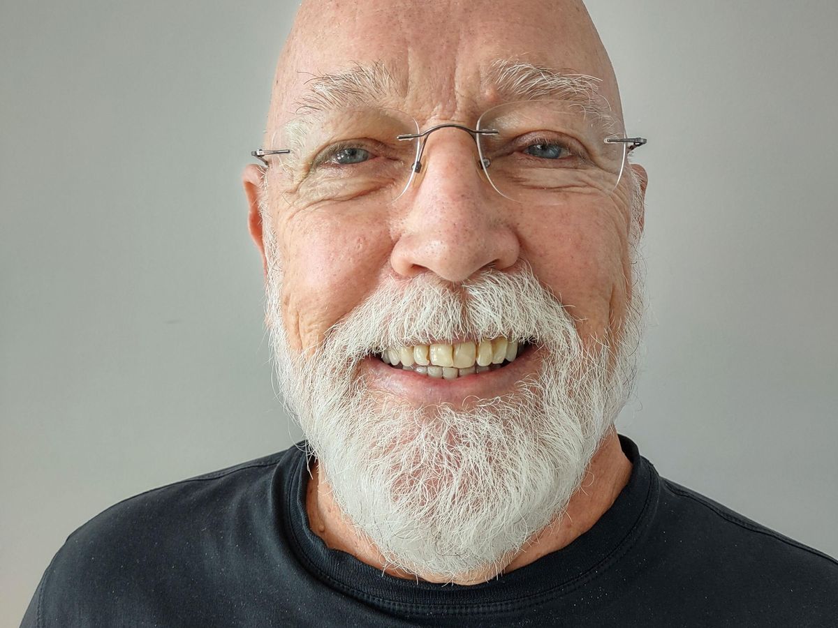 A smiling man with a white beard.