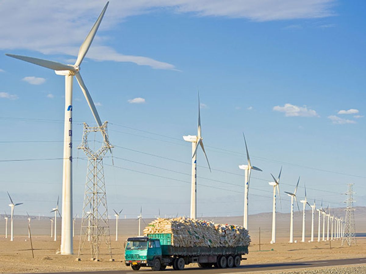 A truck drives past a wind farm in Xinjiang, China.