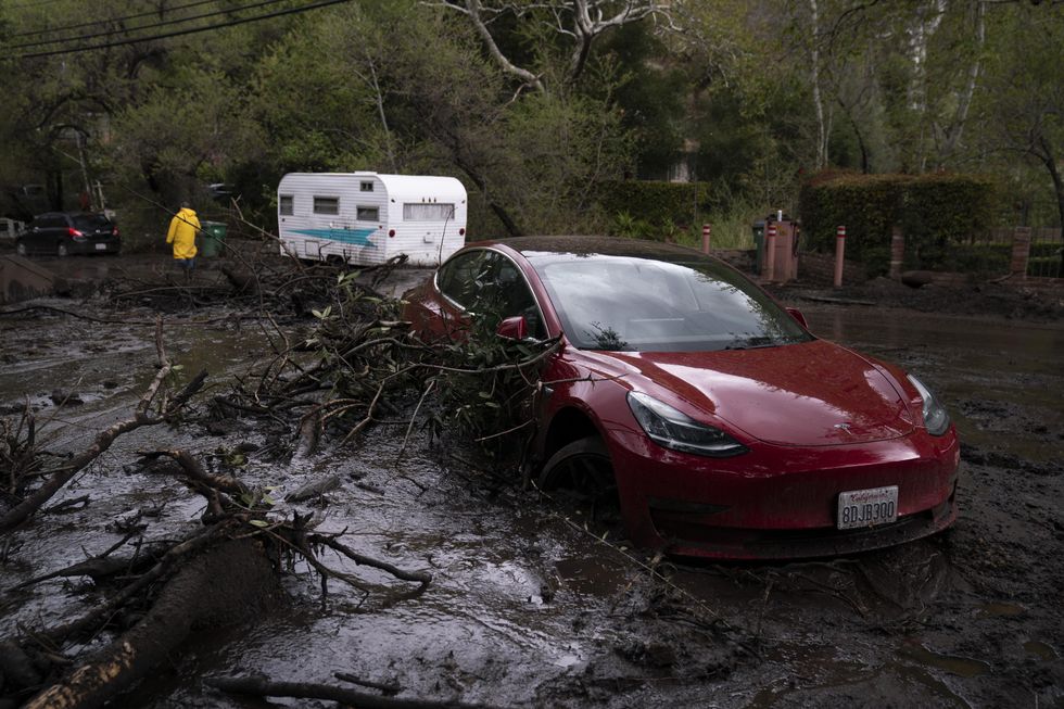 A vehicle is caught up in a mudslide in Silverado Canyon, Calif., Wednesday, March 10, 2021.