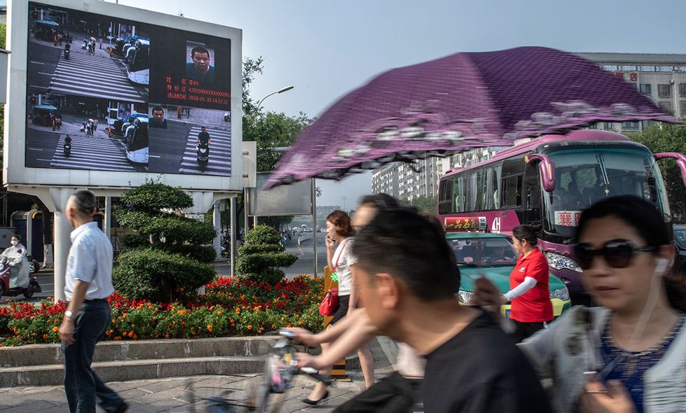 A video billboard in Xinjiang, China, displayed the faces and names of people jaywalking, automatically caught and identified using recognition software. 