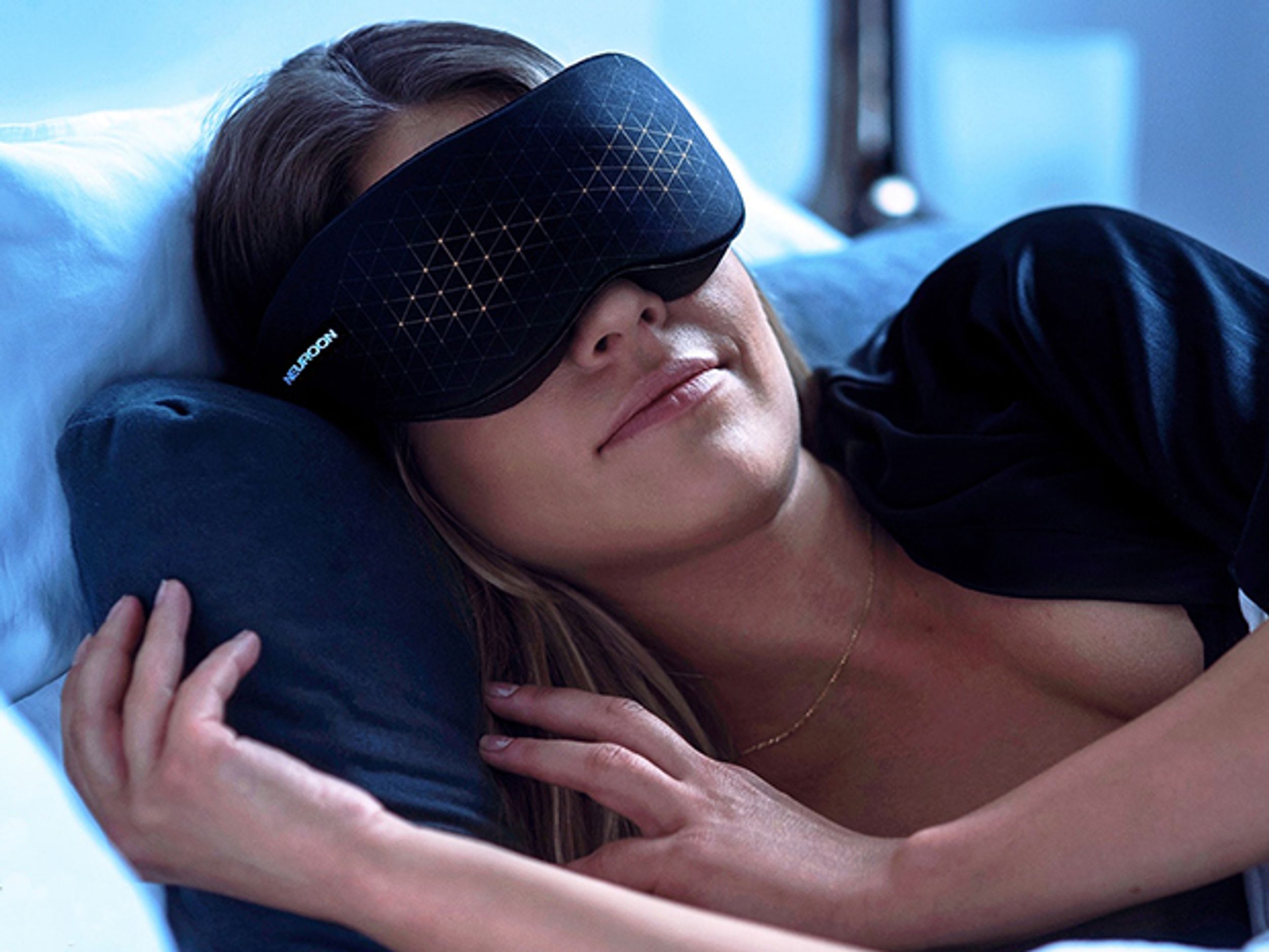 A woman sleeping in bed wearing a black eye mask