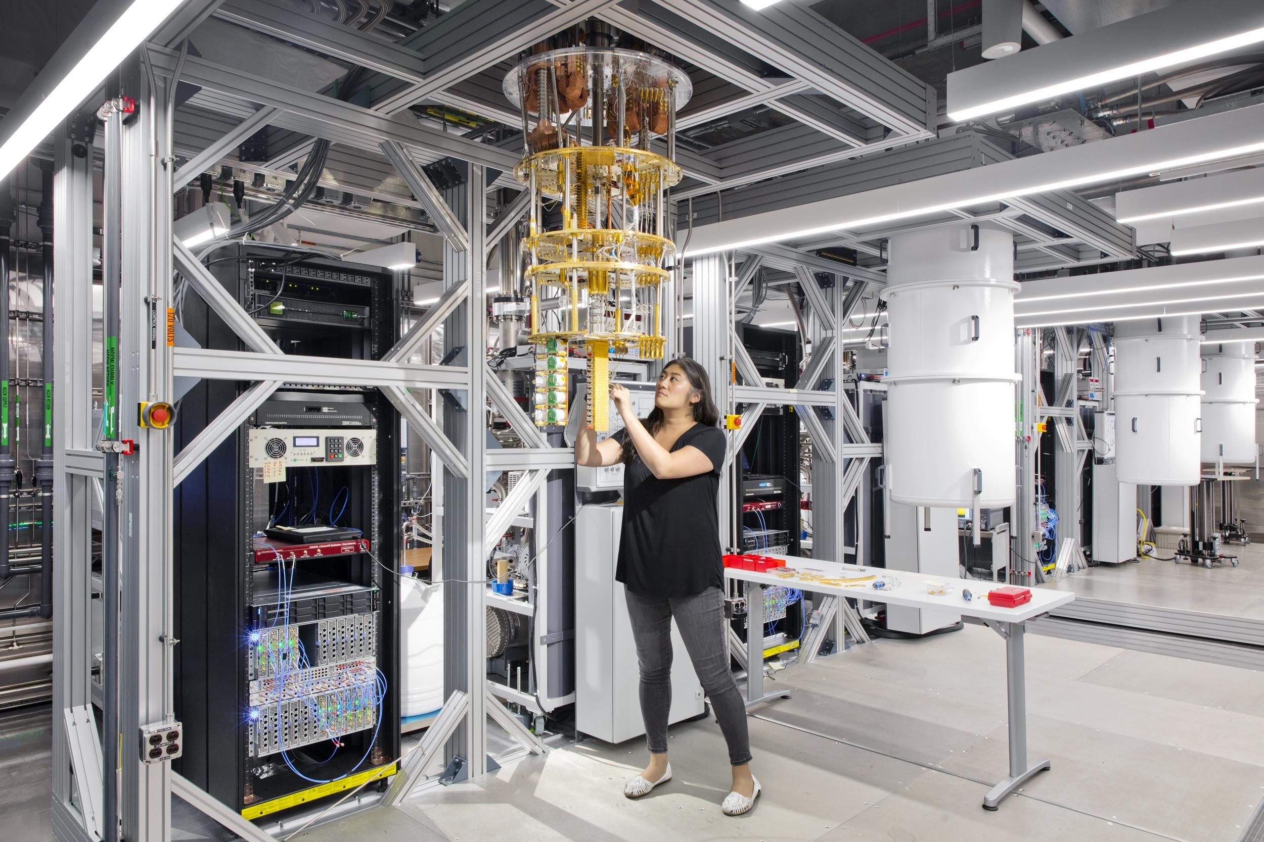 A woman stands in front of quantum equipment 
