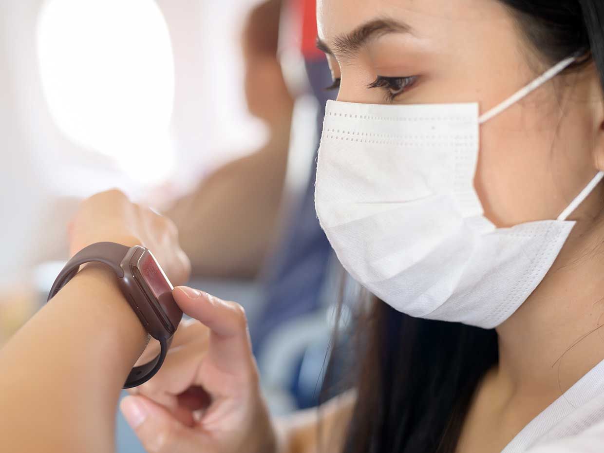 A woman wearing a mask and a smartwatch