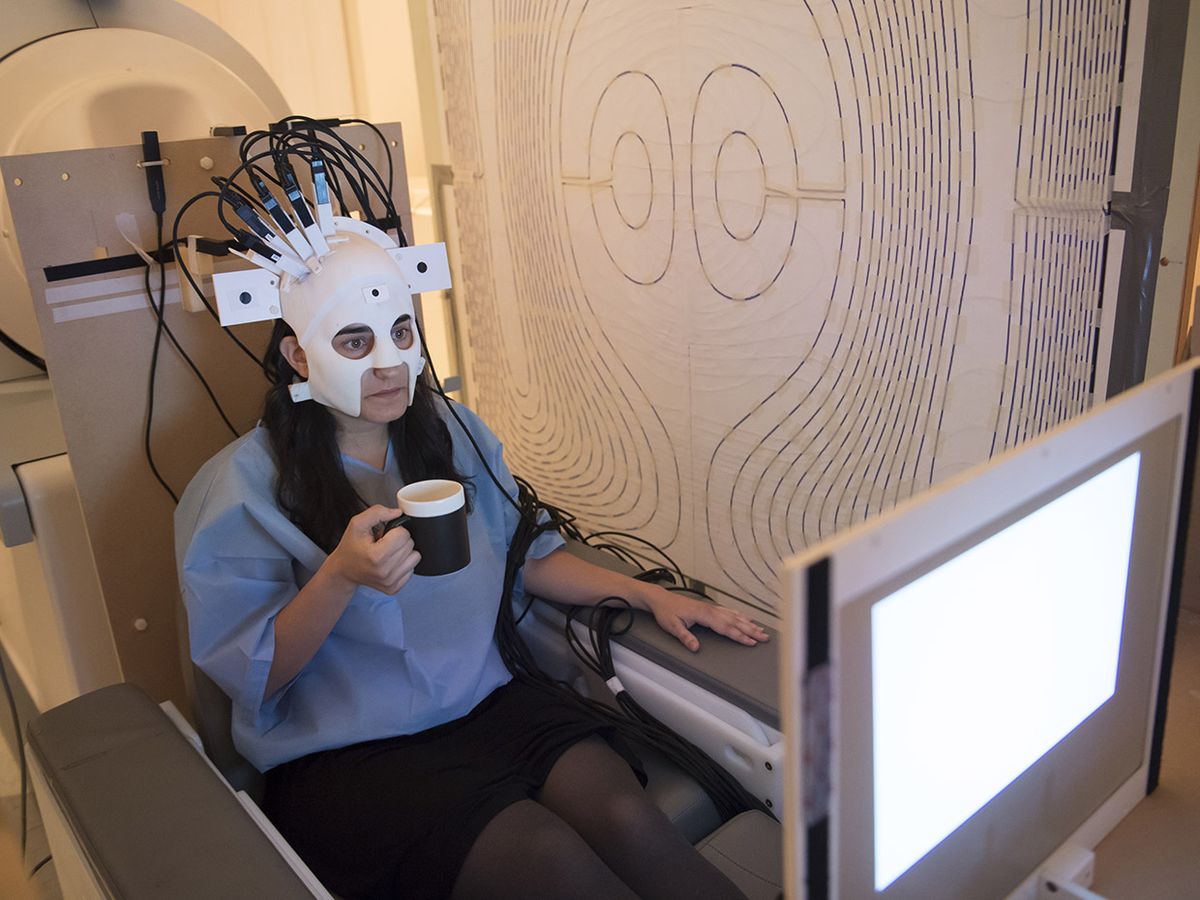 A women with a wearable scanner on her head drinking coffee