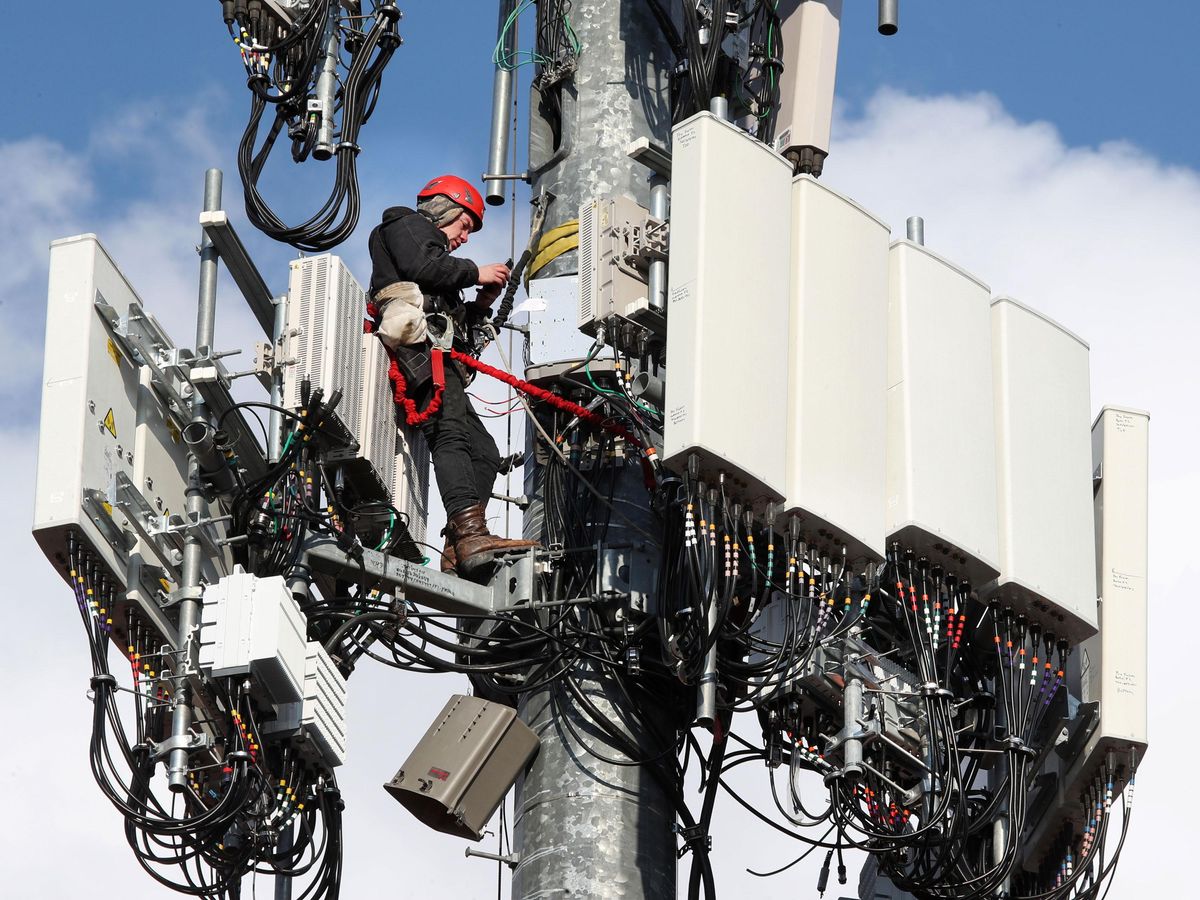A worker rebuilds a cellular tower with 5G equipment in Orem, Utah.