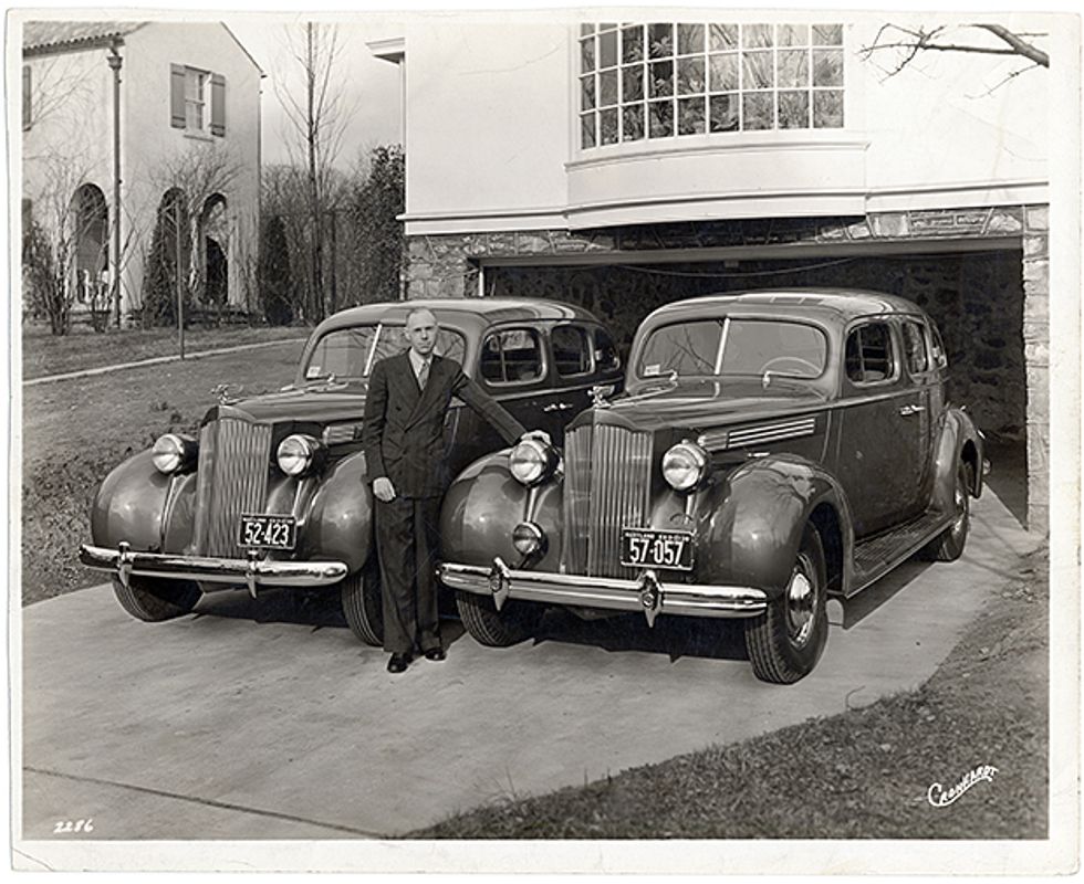 Adler poses with two Packards.