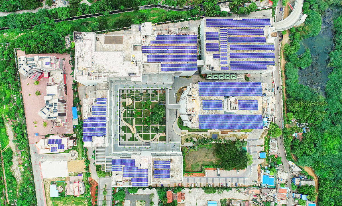 Aerial view of a large office building complex with solar panels on the roof.