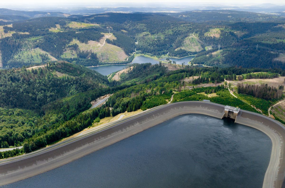 Aerial view of a pumped storage hydropower station, showing the upper and lower reservoirs amidst forests and hills.