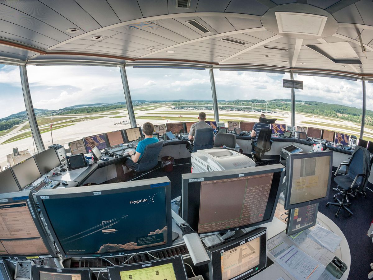 Air traffic controllers in a control tower monitoring the airfield.
