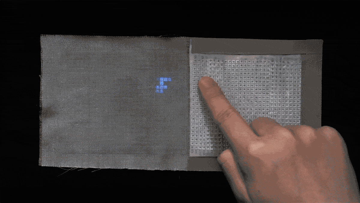 An animated gif clipped from a movie showing a finger moving on a surface on the right, while pixels light up on the opposite side as the finger moves.