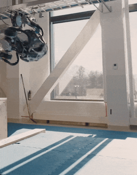 An animated gif showing a humanoid robot stumble and recover after doing a backflip