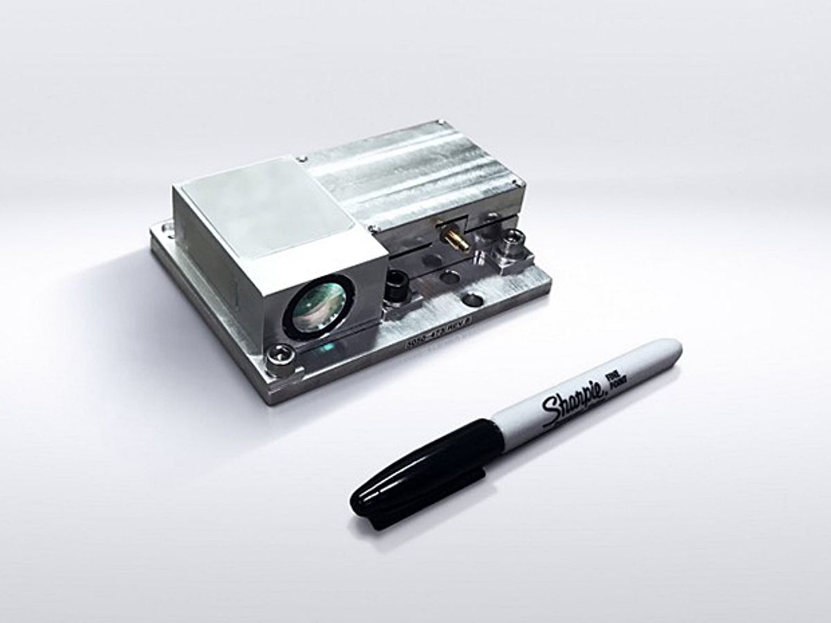 An early lidar prototype from Strobe Inc., which resembles a silver metal box with a green lens, pictured with a Sharpie for scale.