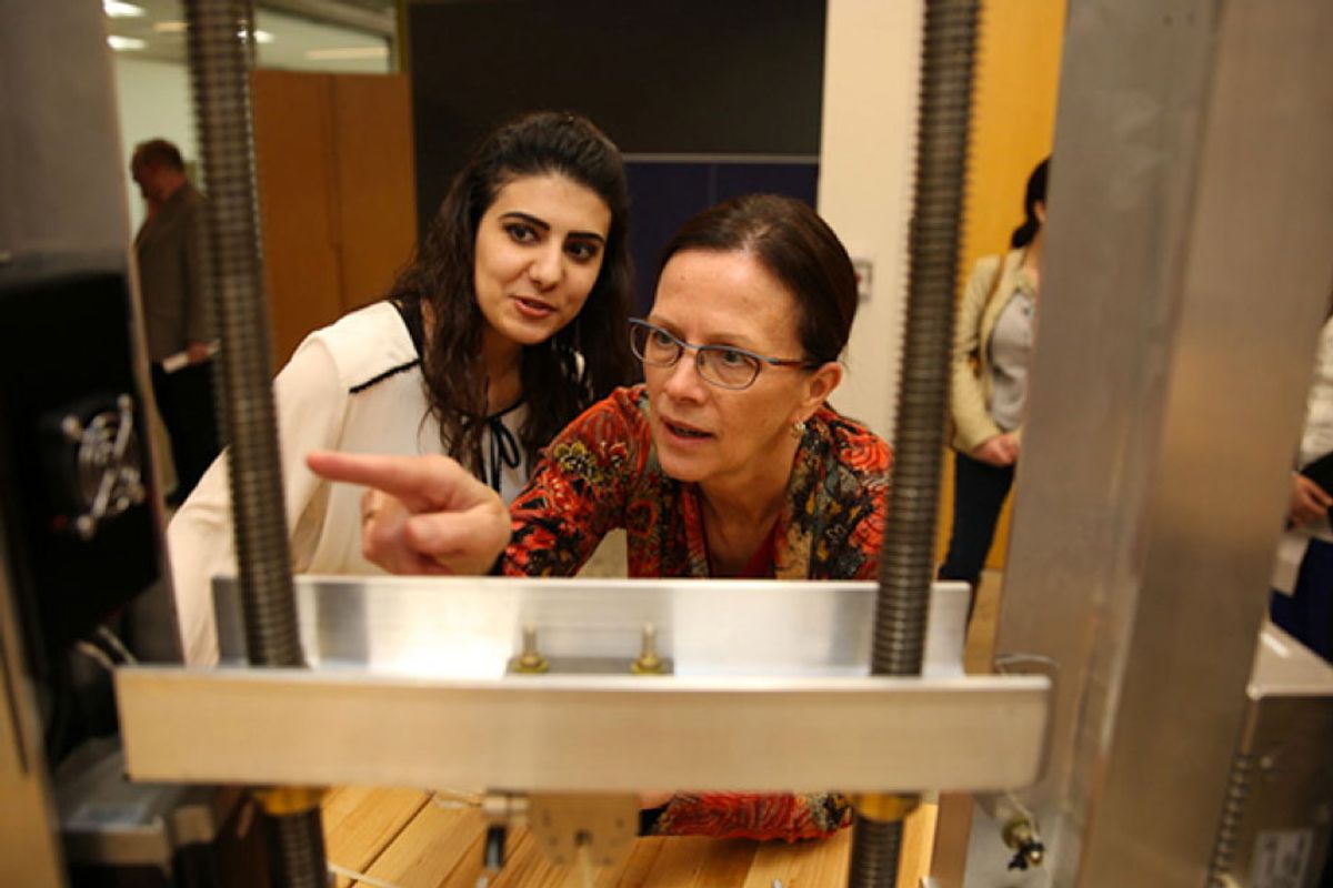 An engineering student at Pennsylvania State University watches Kathryn Jablokow, professor of engineering design and mechanical engineering, examine her capstone project.