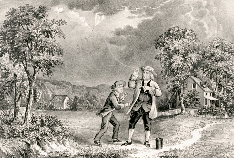 An engraving of a man in 18th-century clothing holding the string of a kite in a thunderstorm, while a young boy stands next to him.  