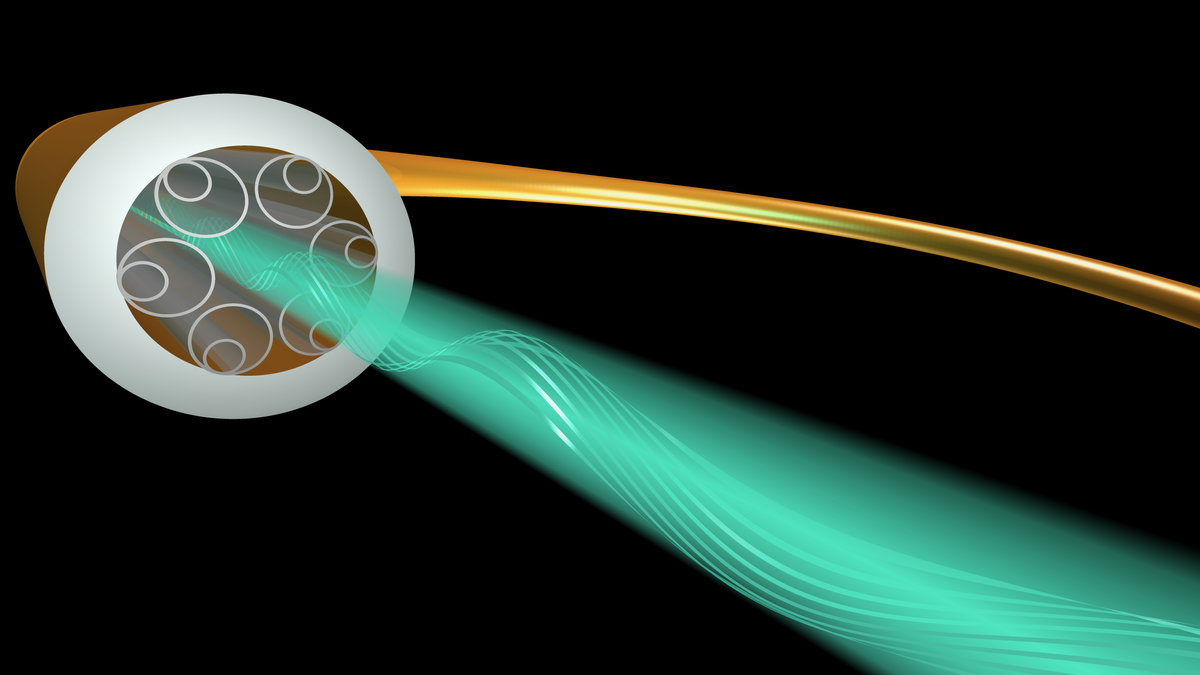 An image of a gold tube with a green beam emerging from it. Around the edge of the tube is a ring of concentric circles.