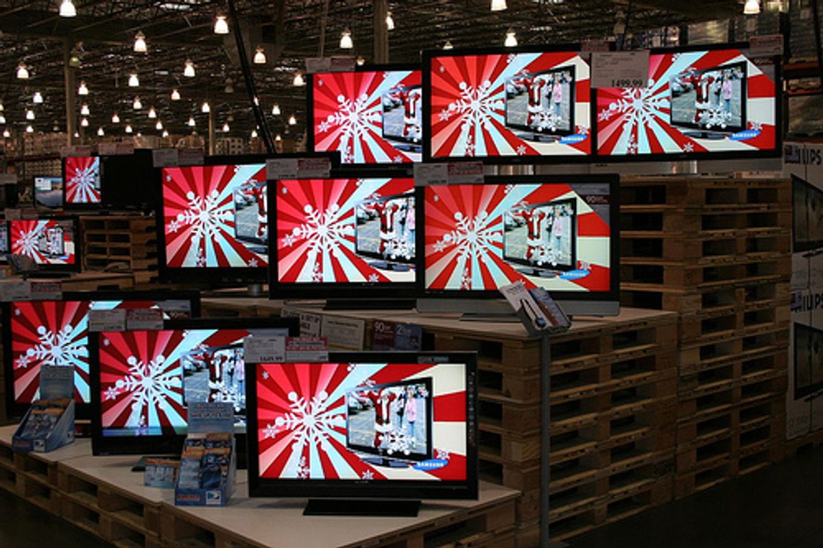 An image of a number of television screens stacked on a rising stand.  