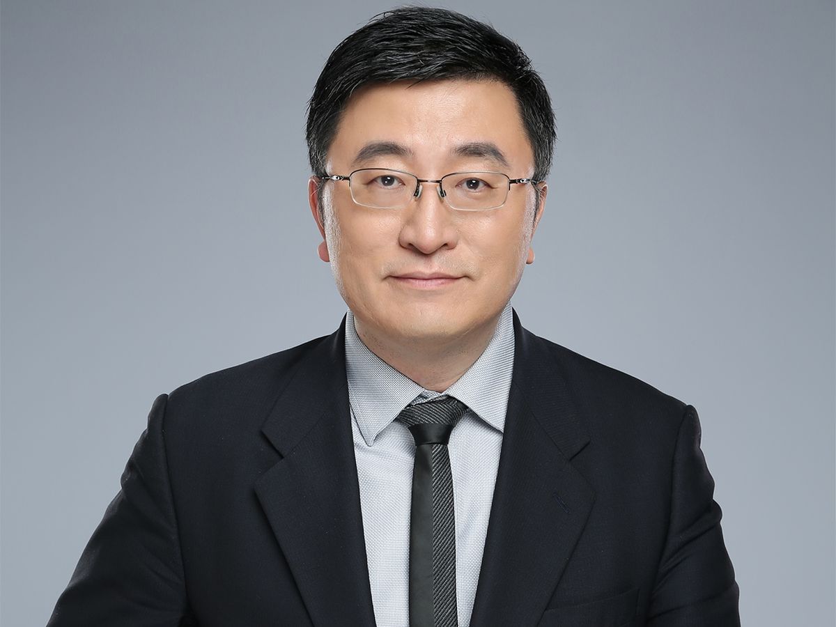 An image of Chenyang Xu on a gray background looking directly into the camera.