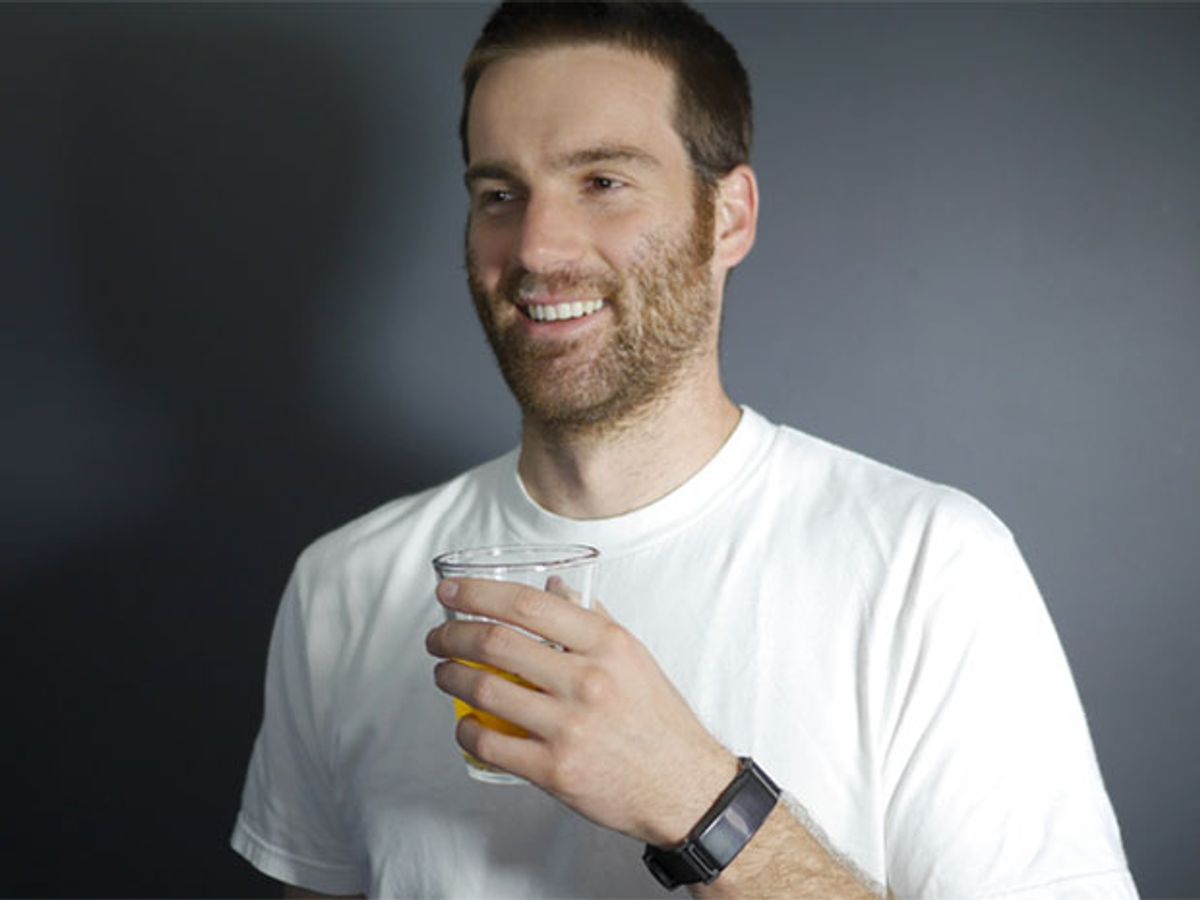 Bearded man with beer in hand and BACtrack alcohol biosensor on wrist.