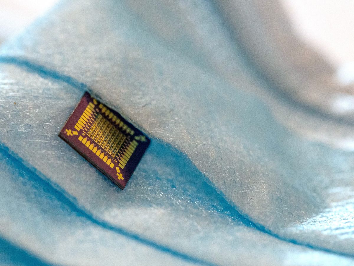black and gold computer chip sitting on a blue pleated surface