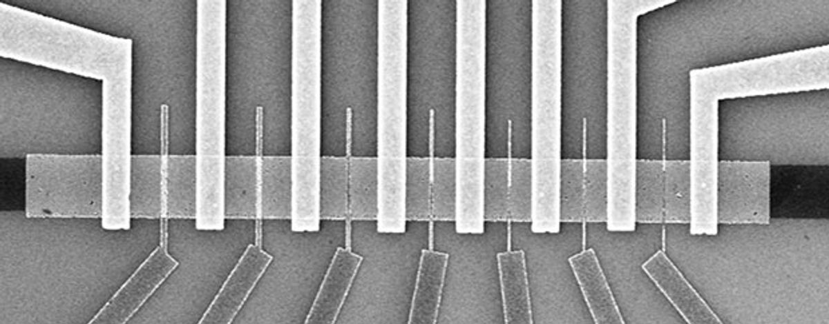 Black and white microscope image of molybdenum disulfide transistors shows vertical bars at top crossing a horizontal bar and vertical bars at bottom intersecting the spaces between them.