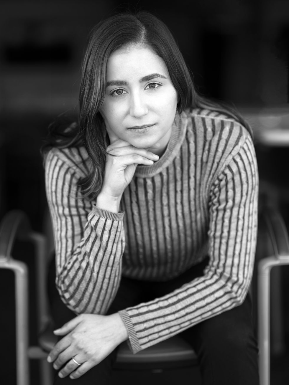 black and white photo of a woman with dark hair and a striped shirt 