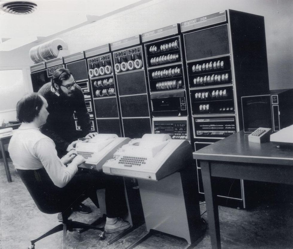  Black and white photo of two men working with a mainframe computer