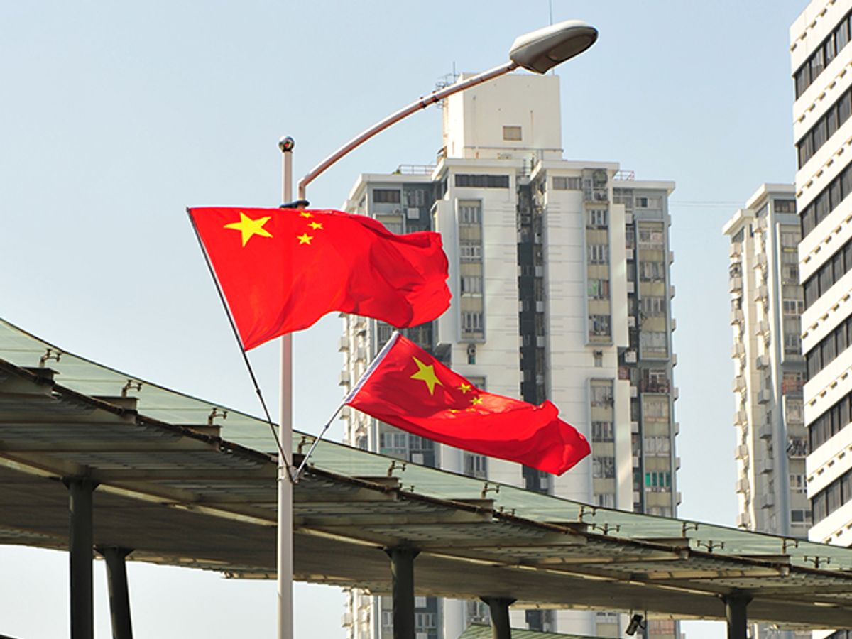 Chinese flags wave near high-rise buildings