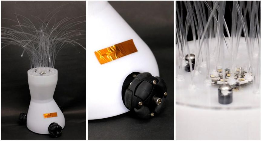 Close up images of the YOLO robot showing wheels, a touch sensor, and a forest of small plastic whiskers with LEDs under them growing out of the robot's head