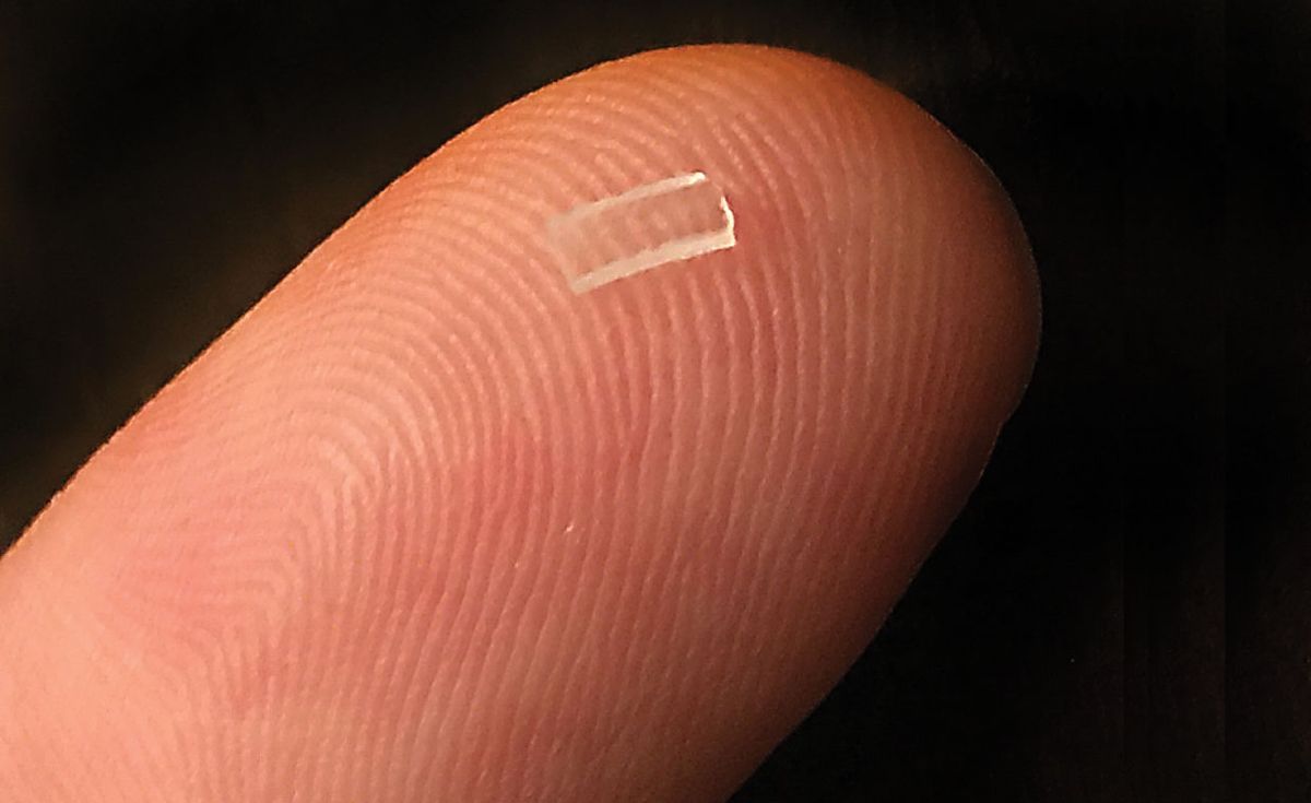 Close up of a finger with a clear square on it.